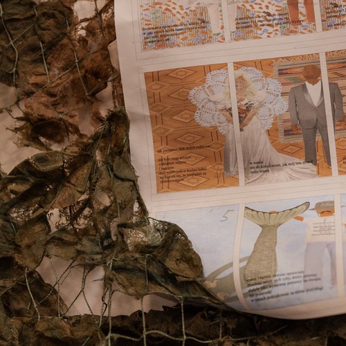 Zbliżenie na fragment komiksu leżącego na siatce rybackiej, przedstawiającego sceny ślubne.