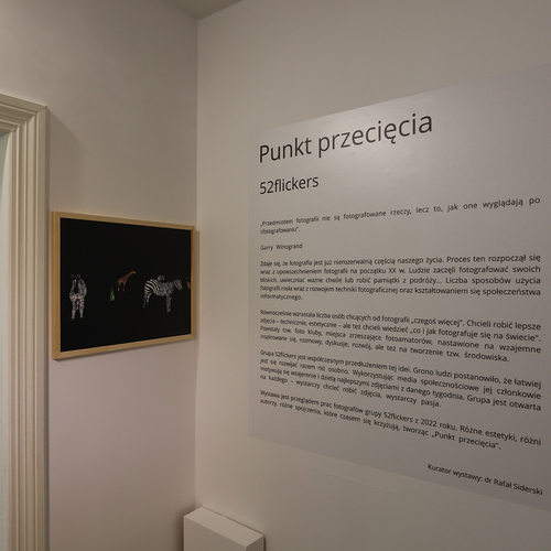 Widok ściany galerii z tekstem wprowadzającym do wystawy „Punkt przecięcia”.